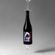 Une bouteille de vin est équilibrée à l'envers sur un verre, avec une illustration artistique représentant une figure allongée sur l'étiquette, incarnant l'essence du vin naturel.