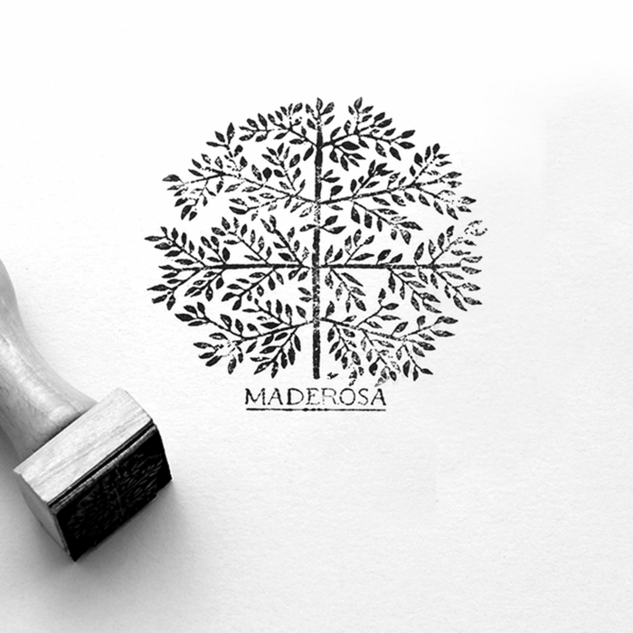 Un timbre présentant une illustration détaillée d'un arbre avec le texte « MADEROSA » en dessous, élégamment présenté sur du papier blanc.